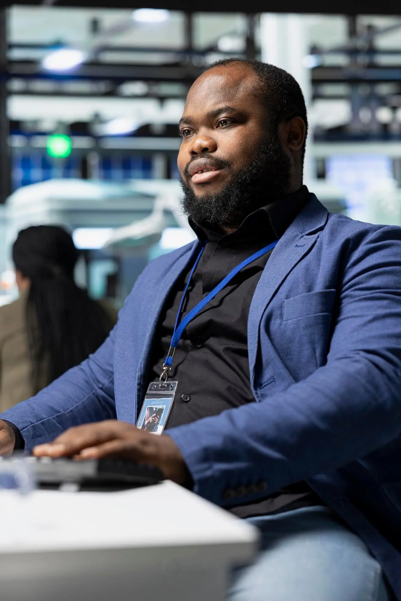 An African American male supervisor monitors production systems on a PC.